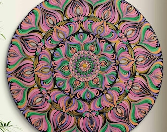Può includere: Un mandala rotondo dipinto a mano con una tavolozza di colori vivaci. Il design presenta un motivo floreale centrale circondato da strati di petali stilizzati in rosa, verde, viola e oro su uno sfondo nero. L'opera d'arte è esposta su una superficie bianca.