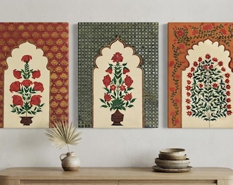 May include: A set of three rectangular wall art canvases featuring arched architectural motifs. Each canvas displays a central potted floral arrangement with red blossoms and green leaves against a cream background, framed by patterned borders in red, green, and orange.