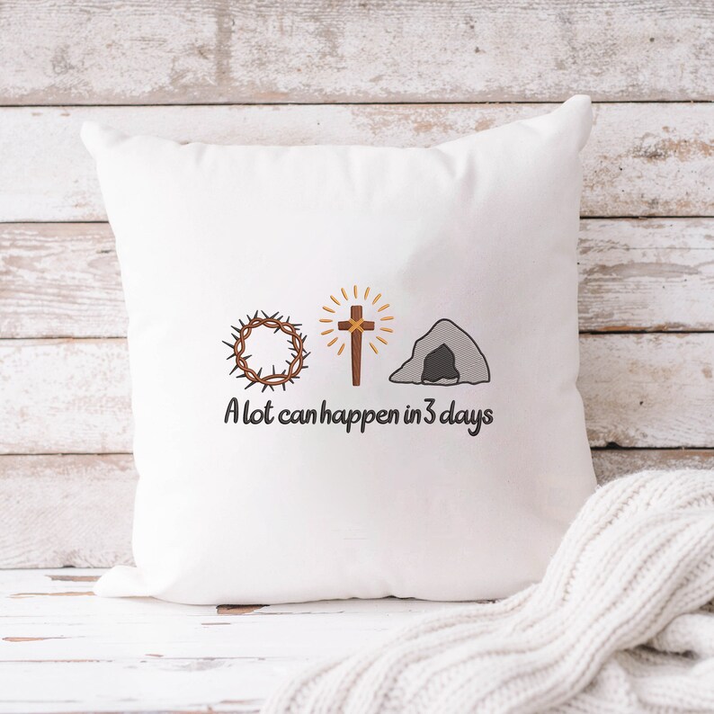 May include: White pillow with embroidered images of a crown of thorns, a cross, and a tomb. The text "A lot can happen in 3 days" is embroidered below the images.