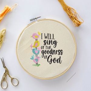 May include: Embroidered hoop art with a white background and four colorful birds stacked on top of each other. The text reads "I will sing of the goodness of God".