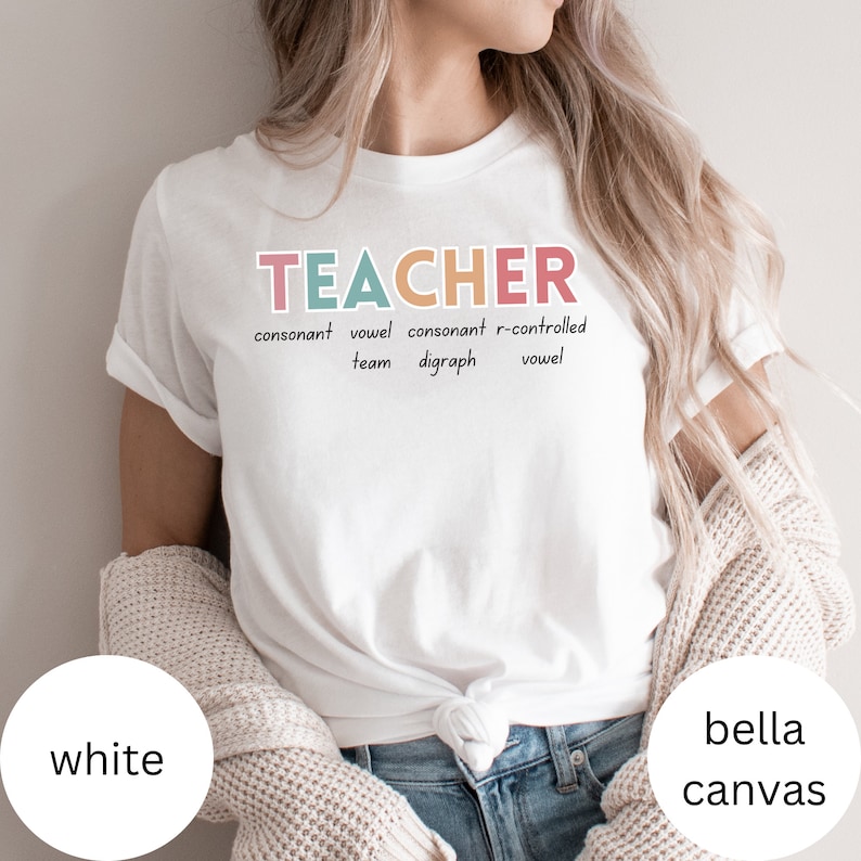 May include: White t-shirt with the word "TEACHER" in colorful letters and the definition of the word written below. The definition includes the words "consonant", "vowel", "digraph", and "r-controlled".