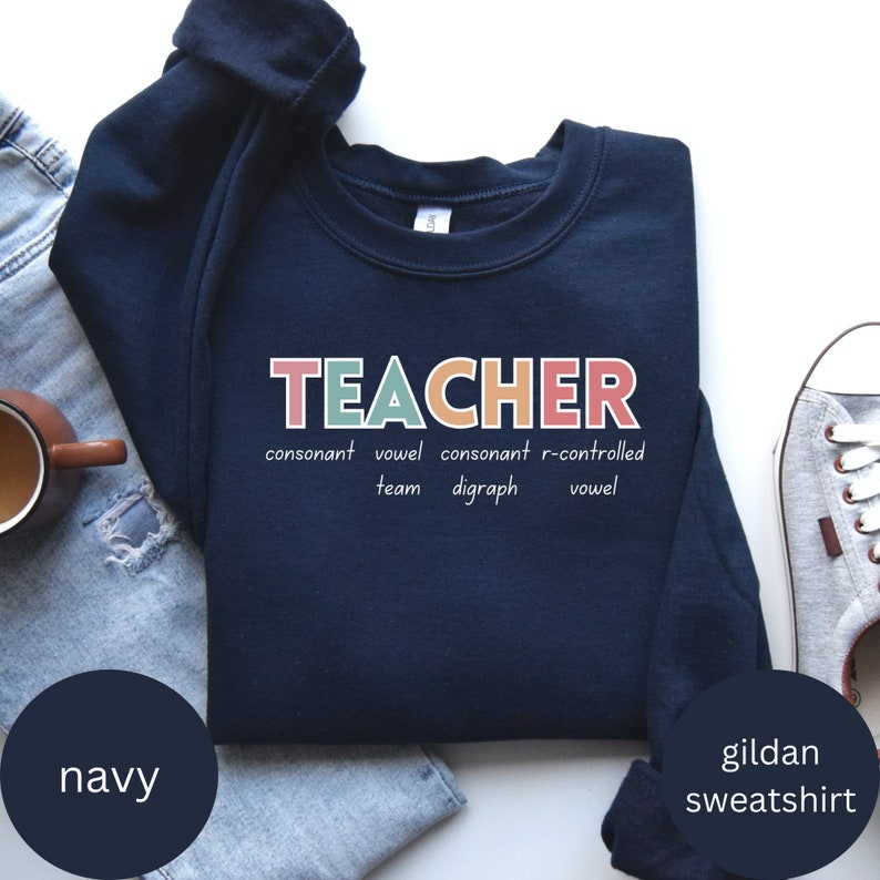 May include: Navy blue Gildan sweatshirt with the word "TEACHER" in colorful letters. The letters are defined as consonant, vowel, consonant, r-controlled vowel, team, digraph.
