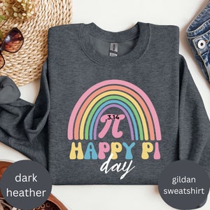 Może przedstawiać: Ciemnoszara bluza Gildan z kolorowym wzorem tęczy i napisem "3.14 &pi; HAPPY PI day". Bluza to swobodny element garderoby, idealny na Dzień Liczby Pi.