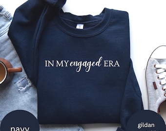 May include: Navy blue sweatshirt with the text "IN MY engaged ERA" in white lettering. Gildan sweatshirt.