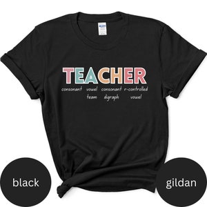 May include: Black t-shirt with the word "TEACHER" in colorful letters. The word is broken down into its parts of speech: consonant, vowel, consonant, r-controlled vowel, team, digraph.