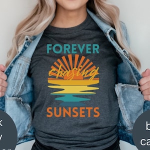 以下が含まれることがあります： レトロな夕焼けのグラフィックと「FOREVER chasing SUNSETS」というテキストが書かれたダークグレーのTシャツです。
