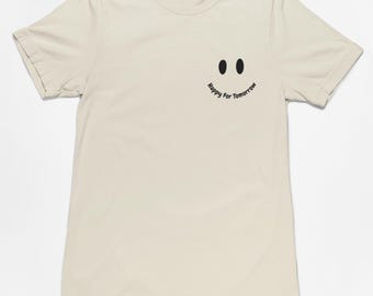 Camiseta beige con cara sonriente Happy for Tomorrow: ¡diseño elegante con el logotipo de una cara sonriente para difundir positividad y alegría donde quiera que vayas!