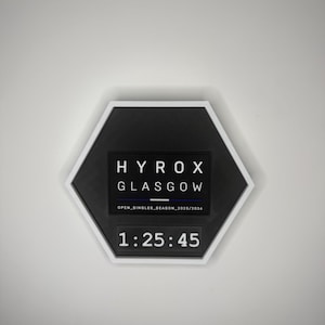 Puede incluir: Una taza de cerámica blanca con un asa negra y el texto "But First, Coffee" en negro, en negrita. La taza está sobre una superficie de madera.