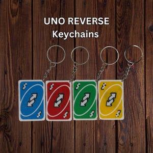 May include: Four UNO Reverse keychains in blue, red, green, and yellow. Each keychain features a card design with a silver chain and ring. The text "UNO REVERSE Keychains" is at the top.