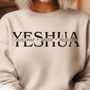 May include: A beige sweatshirt with the text "YESHUA redeemer · savior · deliverer" printed in black.