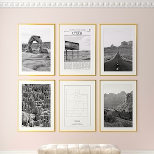 May include: A gallery wall with six framed black and white photographs of Utah landscapes and a map of Utah. The frames are gold.