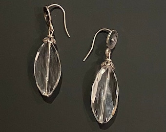 Puede incluir: Un par de pendientes de plata con gotas de cristal facetado transparente.