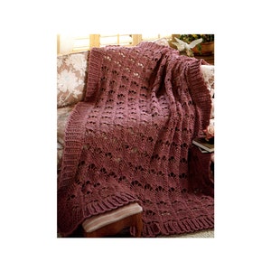 May include: A burgundy crocheted throw blanket with a lacy pattern, draped over a couch.