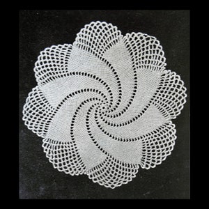 May include: White crocheted doily with a spiral design.