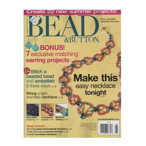 Puede incluir: La portada de una revista de manualidades, "BEAD & BUTTON", presenta un collar de cuentas rojas, azules y verdes. El texto incluye "¡Crea 22 nuevos proyectos de verano!" y "Haz este collar fácil esta noche". También se enumeran otros proyectos.