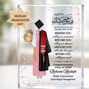 May include: A clear acrylic graduation gift with a stylized illustration of a graduation gown, cap, and bouquet. The text includes "Muslim Graduation Gift", "Class of 2026", and a congratulatory message. The gift is personalized with a name and university.