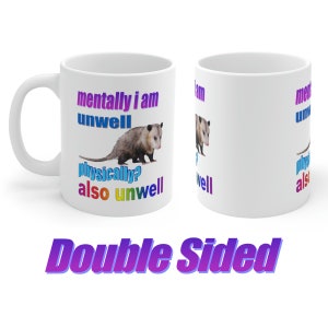 May include: White ceramic mug with a colorful graphic of an opossum and the text "mentally i am unwell physically? also unwell" on one side and the text "mentally i am unwell physically? also unwell" on the other side. The mug is double-sided.