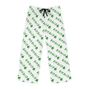 Puede incluir: Pantalón de pijama blanco con un patrón pixelado verde que repite la frase "Bit Drip" en todo.