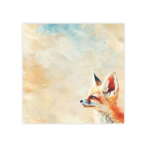 May include: Square print featuring a watercolor illustration of a fox. The fox has orange and white fur, a black-tipped ear, and blue eyes. The background has a watercolor wash of beige, blue, and orange.