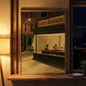 May include: A framed print of a painting depicting a nighttime diner scene. The diner, labeled "Bob's Burgers," features patrons inside. The artwork is set against a city street backdrop, with a warm, inviting glow emanating from the diner's interior.