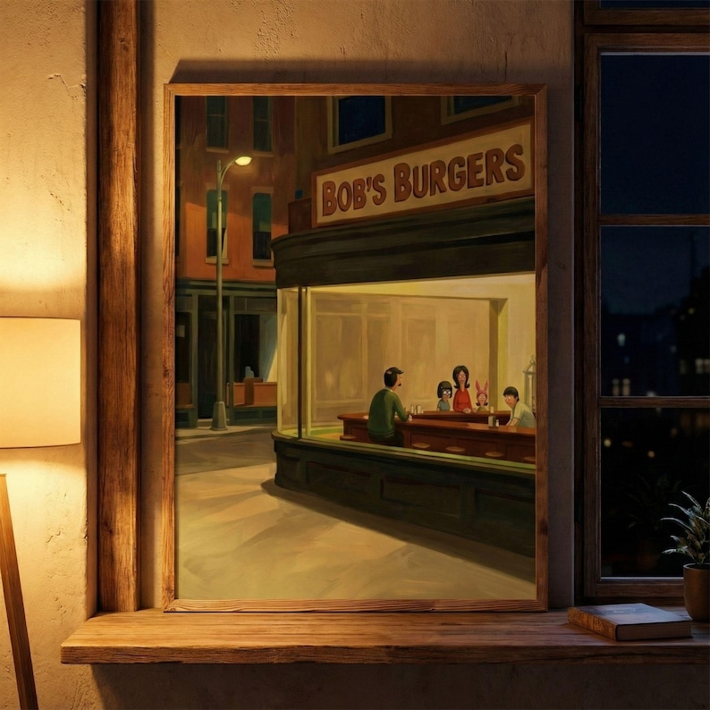 May include: A framed print of a painting depicting a nighttime diner scene. The diner, labeled "Bob's Burgers," features patrons inside. The artwork is set against a city street backdrop, with a warm, inviting glow emanating from the diner's interior.