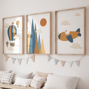May include: A light wood storage bench with six white bins. The bench is decorated with a garland of colourful flags. Three framed prints hang above the bench, featuring a hot air balloon, a mountain range, and a plane.