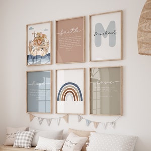 Puede incluir: Una habitación de bebé con un banco de almacenamiento de madera con contenedores beige y blancos. La pared está decorada con seis impresiones enmarcadas, incluyendo un arcoíris, un arca de Noé y una cita sobre la fe. Las impresiones están en un esquema de color azul claro, marrón y rosa.