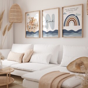 May include: Three framed prints with a nautical theme. The first print features a cartoon illustration of Noah's Ark with animals on board. The second print features the name Noah in a blue and white font. The third print features a rainbow with brown and orange stripes and the text "You are fearfully and wonderfully made" with a reference to Psalm 139:14.