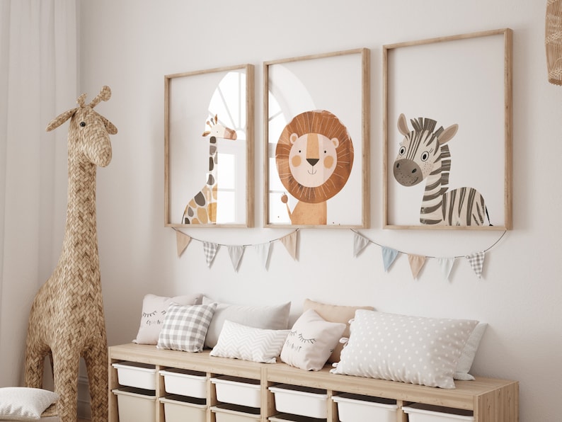 May include: Three framed illustrations of animals in a nursery setting. The illustrations feature a giraffe, a lion, and a zebra. The frames are light wood and the illustrations are in a cartoon style.