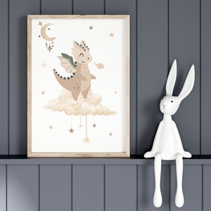 May include: A framed print of a cartoon dragon with brown and green wings, sitting on a cloud with stars hanging from it. The dragon is smiling and has a light brown body with a light brown cloud behind it. The background is white with gold stars.