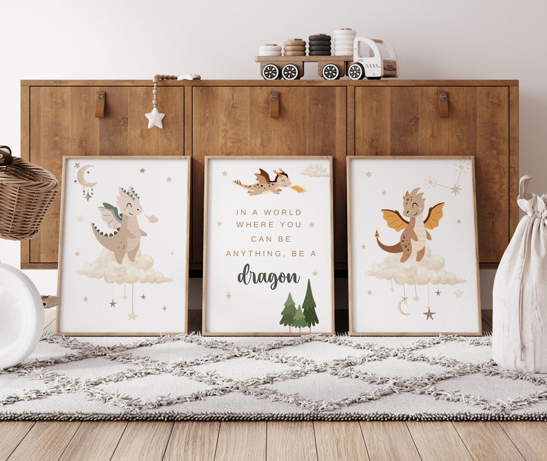May include: Three framed prints with a whimsical illustration of a dragon on a cloud with stars and a crescent moon. The middle print has the text "In a world where you can be anything, be a dragon."