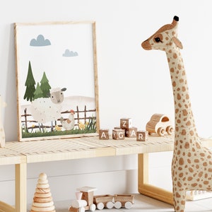 May include: A framed illustration of a white sheep, a brown hen, and yellow chicks in a green field with trees and a wooden fence. The illustration is hanging on a white wall above a wooden bench with a stuffed giraffe, wooden blocks, and a wooden toy train.