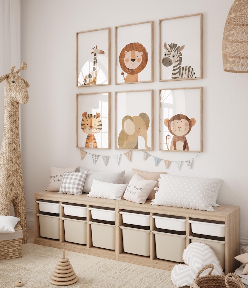 May include: A set of six framed animal prints featuring a giraffe, lion, zebra, tiger, elephant, and monkey. The prints are in a nursery setting with a wooden storage bench and other decor.