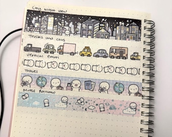 Puede incluir: Cinco tiras de cinta decorativa washi aplicadas en una página de cuaderno de puntos. Los diseños incluyen una vista nocturna de la ciudad, camiones y coches, emojis verticales, iconos de viaje con globos terráqueos y un arcoíris suave.