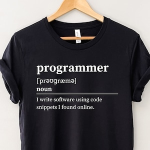 May include: Black t-shirt with a white graphic that says "programmer" and defines the word as "I write software using code snippets I found online."