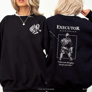 May include: A black crewneck sweatshirt featuring a white graphic on the left chest and a large white graphic on the back. The back design displays a knight illustration with the text EXECUTOR NIGHTREIGN and Clear your thoughts. Accept your fate.