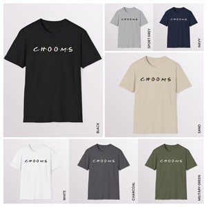 May include: A collection of t-shirts in various colors, including black, white, gray, navy, sand, and military green. Each shirt features the word "CHOOMS" in a stylized font across the chest. The shirts are short-sleeved and made of a soft material.