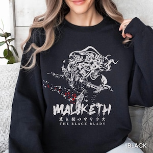 May include: A white ceramic mug with a black handle and the text "But First, Coffee" in a black, handwritten-style font. The mug is on a white surface.