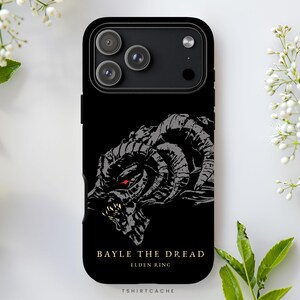 May include: Black phone case featuring a gray illustration of a horned creature with red eyes. The text "BAYLE THE DREAD ELDEN RING" is printed below the image. The case has a glossy finish and a camera cutout.
