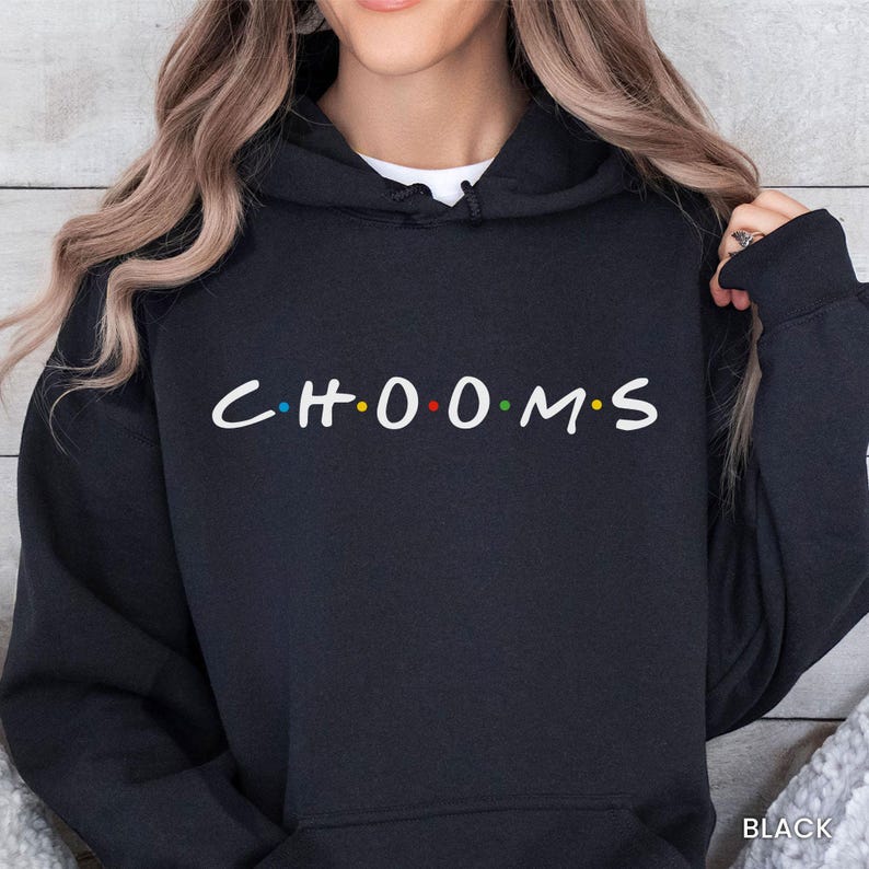 May include: Black hooded sweatshirt with the word "CH00MS" printed across the chest in a white font. The letters "O" are colored in red, blue, and green. The word "BLACK" is printed in white at the bottom right.