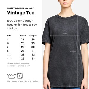 May include: A dark gray unisex mineral washed vintage tee. The shirt is 100% cotton jersey, regular fit, and true to size. Measurements are provided in inches, with a width of 18 inches and a length of 28 inches for size small.