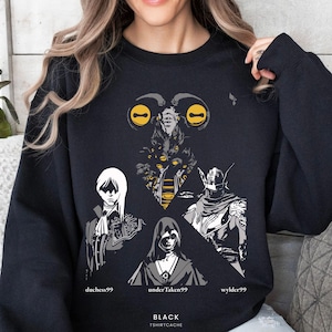May include: Black sweatshirt featuring a graphic design with several figures and the text "duchess99", "underTaken99", and "wylder99". The design includes yellow and gray accents. The text "BLACK" and "TSHIRTCACHE" are also present.