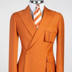 May include: A bright orange blazer with a single button closure and two large patch pockets on the front. The blazer has a white collar and a white and orange striped tie.