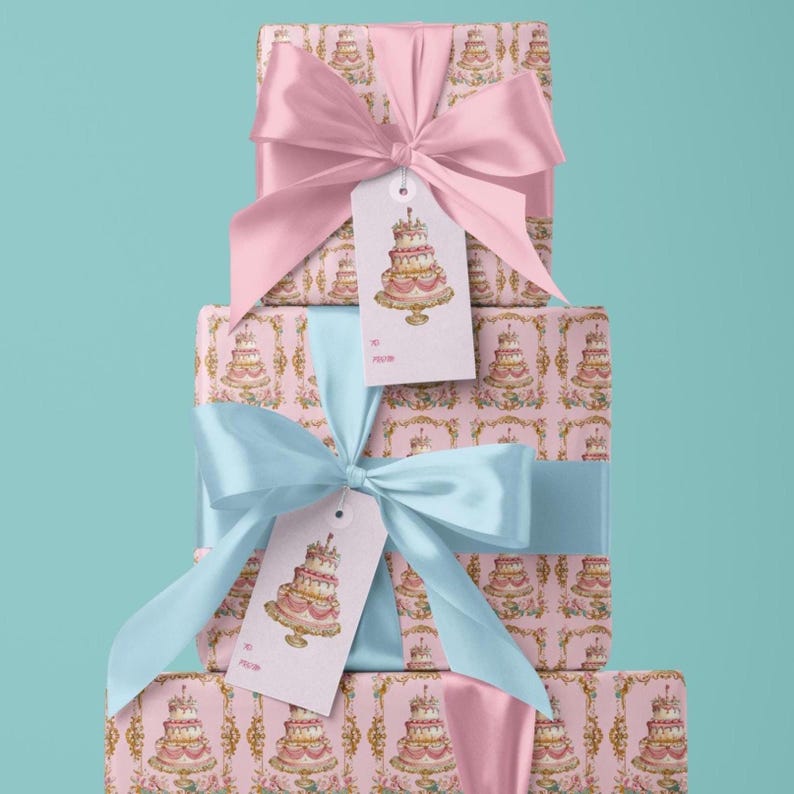 May include: Three pink gift boxes with a cake pattern and gold accents. The boxes are stacked on top of each other. The top box has a pink ribbon and a gift tag with a cake illustration. The middle box has a blue ribbon and a gift tag with a cake illustration. The bottom box has a pink ribbon.
