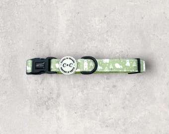 May include: A green dog collar with a white polar bear print and a black buckle. The collar has a round metal tag with the text "Cookies & Crumbles" and the initials "C&C".