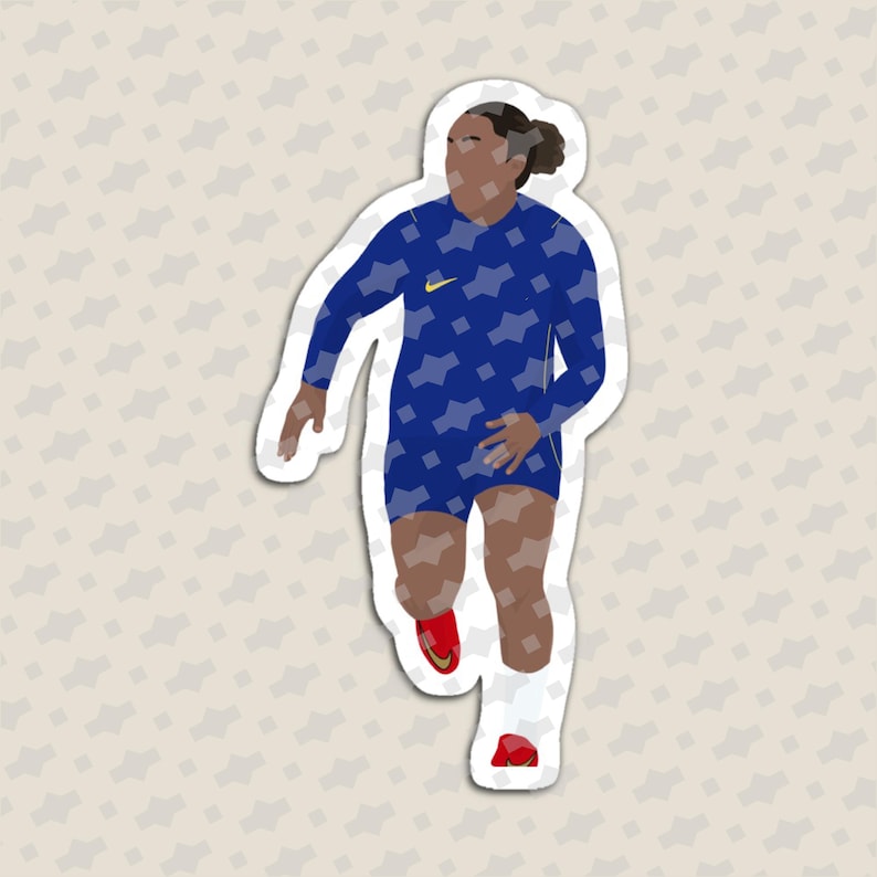 May include: A die-cut sticker featuring a stylized illustration of a soccer player in a blue long-sleeve jersey with a geometric pattern, dark blue shorts, white socks, and red cleats. The player has dark hair tied back and a yellow logo on the chest.