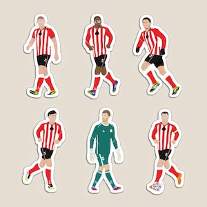 Op de afbeelding: Een set van zes stickers met gestileerde illustraties van voetballers. De spelers dragen rood-wit gestreepte shirts, zwarte shorts en rode sokken. Eén speler draagt een groen keepersuniform.