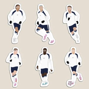 May include: Six die-cut stickers showing illustrations of soccer players in white and navy kits. The players are in motion, with black gloves and pink or blue boots. The stickers are ideal for decorating items.