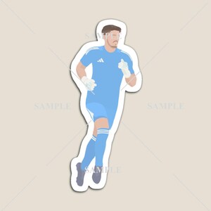 May include: A light blue sticker featuring a soccer goalkeeper in a running pose. The goalkeeper is wearing a light blue uniform with white accents, gloves, and socks. The sticker has a white border and a neutral background.