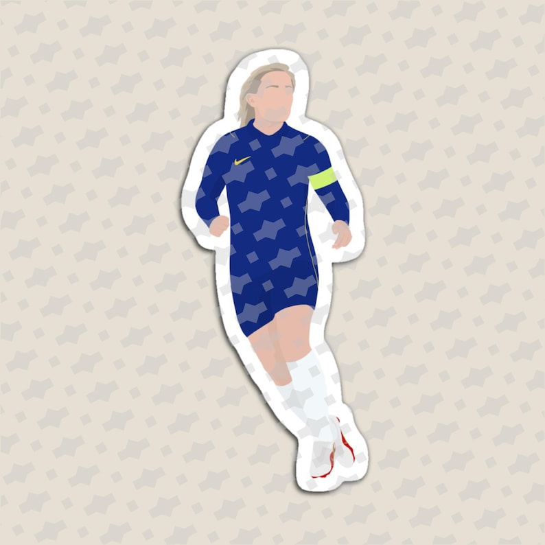 May include: A die-cut sticker featuring a stylized illustration of a soccer player in a dark blue jersey with a light blue geometric pattern, a yellow logo, a lime green captain's armband, white shorts, and white socks with red accents.